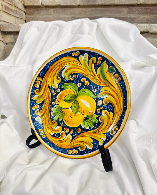 Decorative ceramic plate with lemon design on a white fabric background