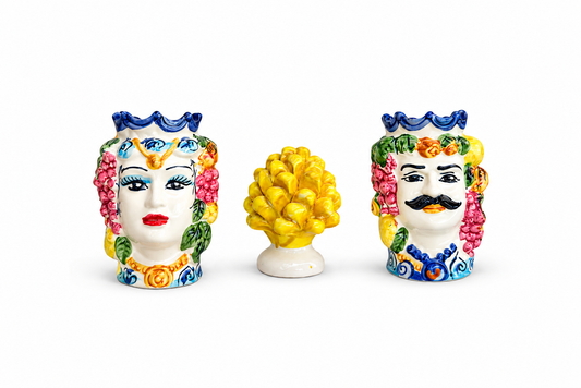 Three colorful ceramic head figurines on a white background