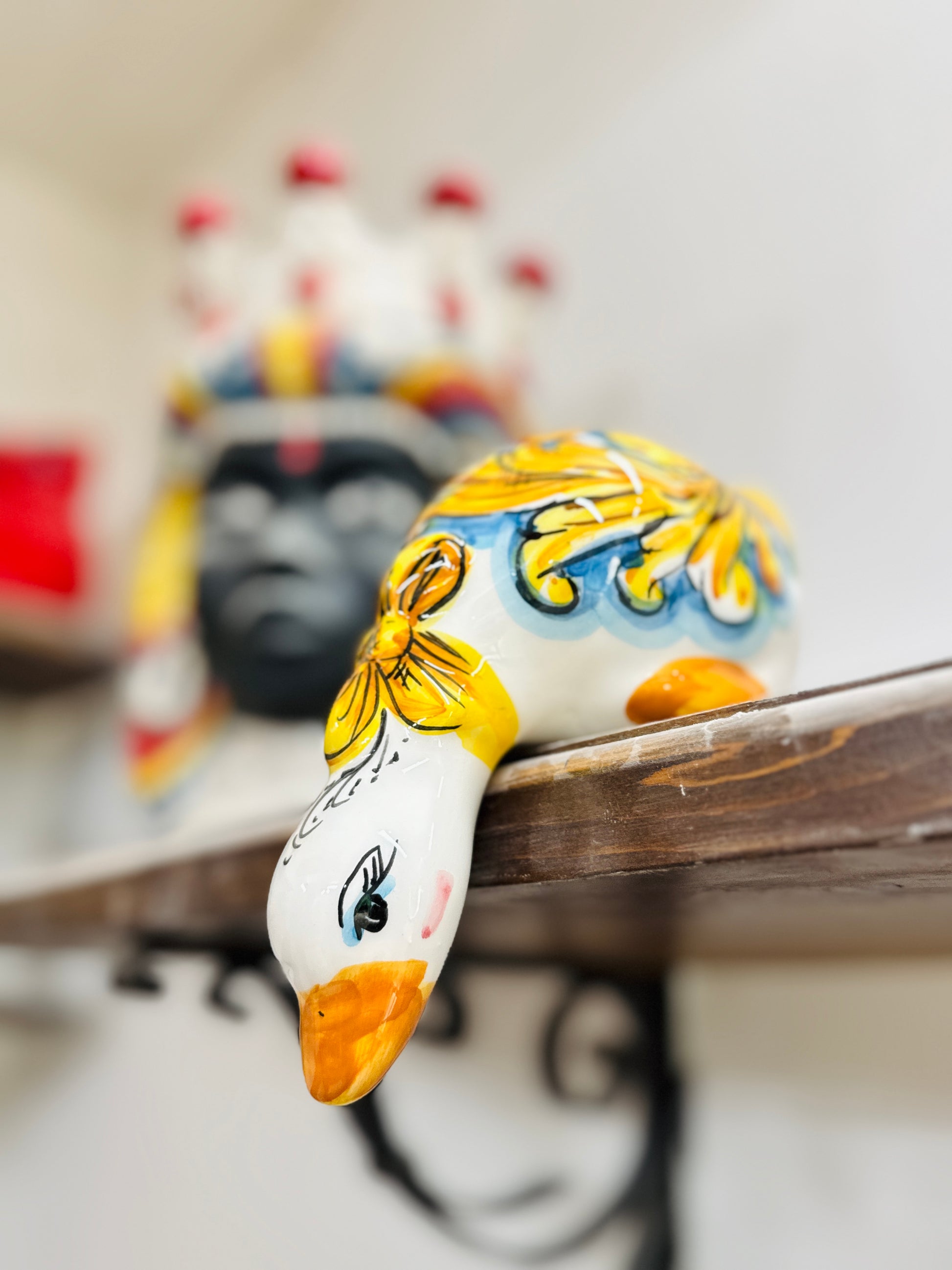 Decorative ceramic goose with colorful patterns on a shelf.