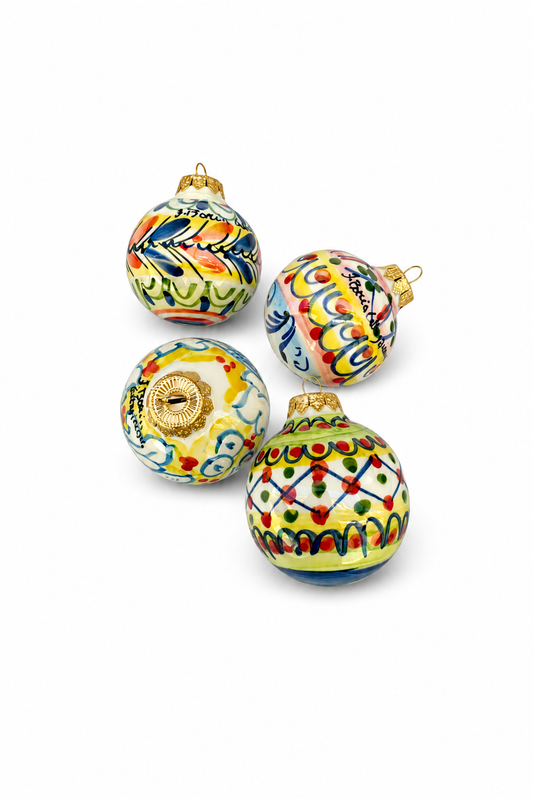 Set of four colorful glass Christmas ornaments on a white background