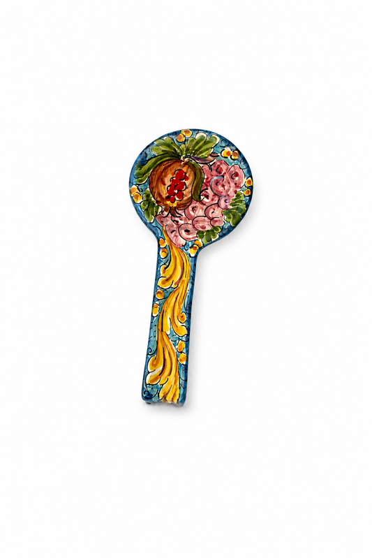 Decorative spoon with floral and fruit design on a white background