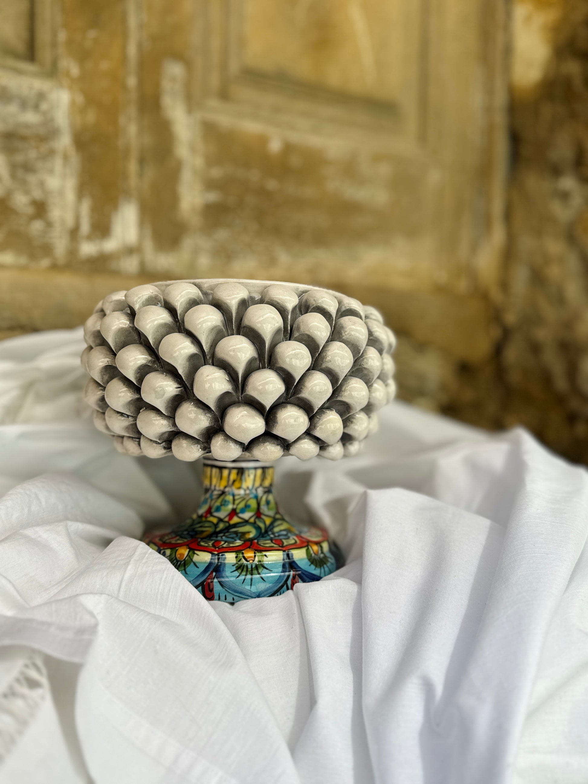 Handcrafted Sicilian ceramic pigna centerpiece bowl
Sculptural Mediterranean ceramic bowl with pine cone texture
Italian artisan ceramic centerpiece inspired by Sicilian pigna