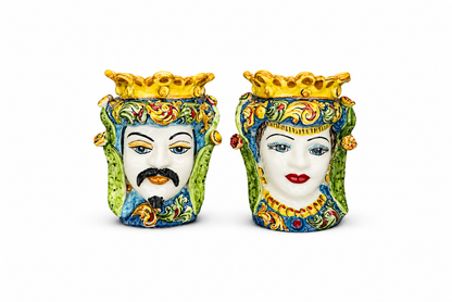 Two decorative ceramic vases shaped like faces with colorful patterns on a white background