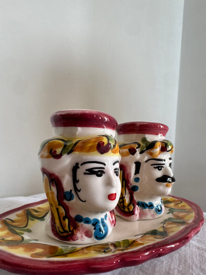 Close-up of handcrafted Sicilian Moor head salt and pepper shakers with hand-painted details and matching tray.