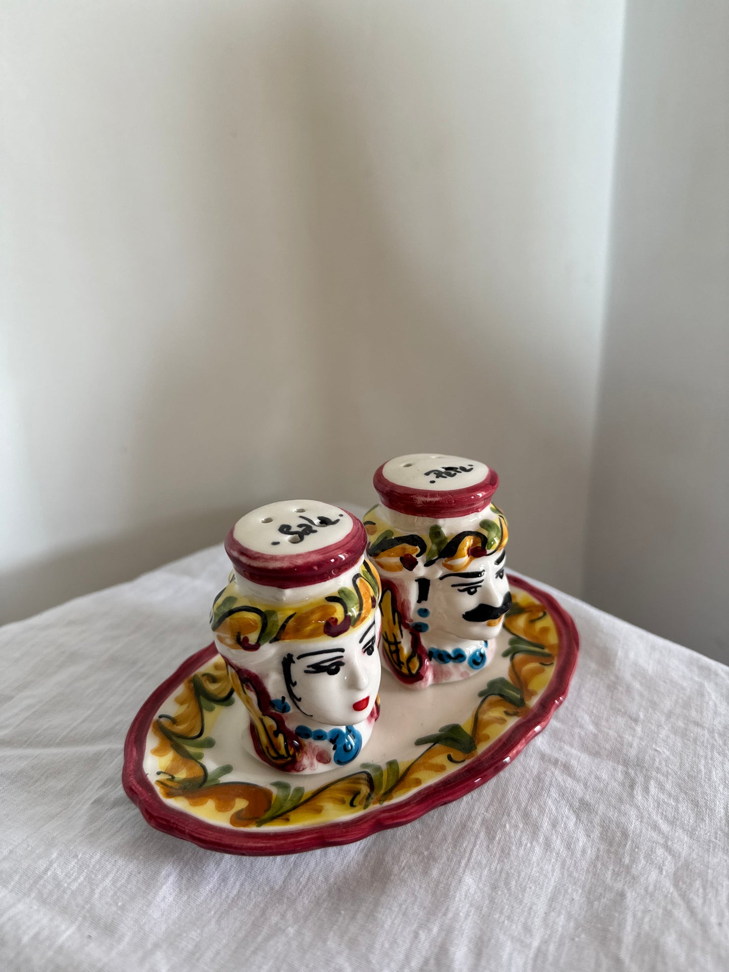 Top view of a handcrafted Sicilian ceramic salt and pepper set with traditional Moor head decorations.