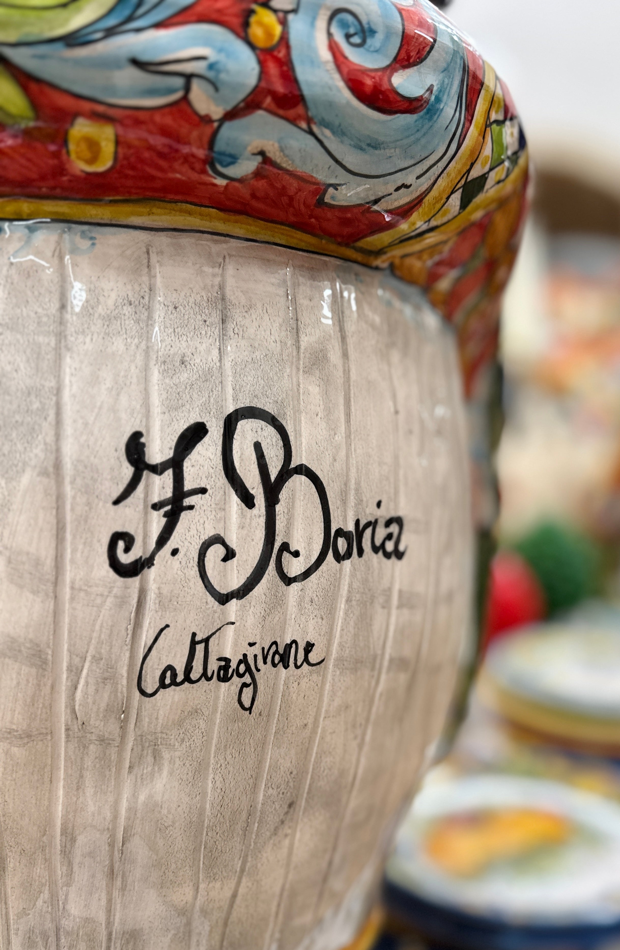 Close-up of the artisan signature ‘F. Boria Caltagirone’ on a handcrafted Sicilian ceramic piece with colorful traditional majolica details.