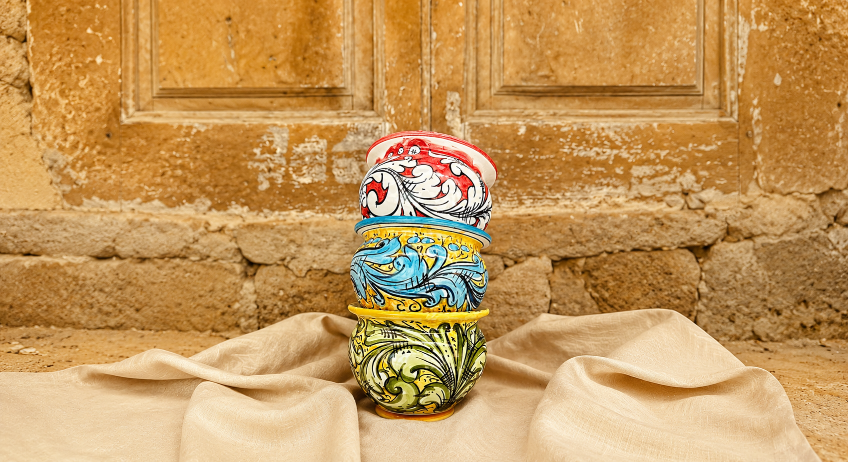 Colorful handcrafted Sicilian ceramic vases from Caltagirone displayed in a rustic Mediterranean setting with traditional majolica patterns and warm earthy tones.