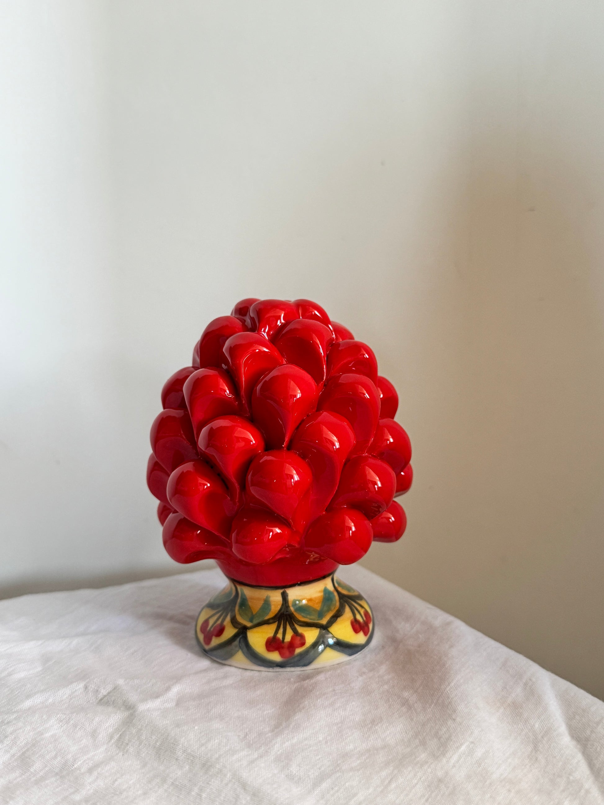 Handcrafted red Sicilian ceramic pine cone decoration inspired by traditional Caltagirone artistry and Mediterranean design.