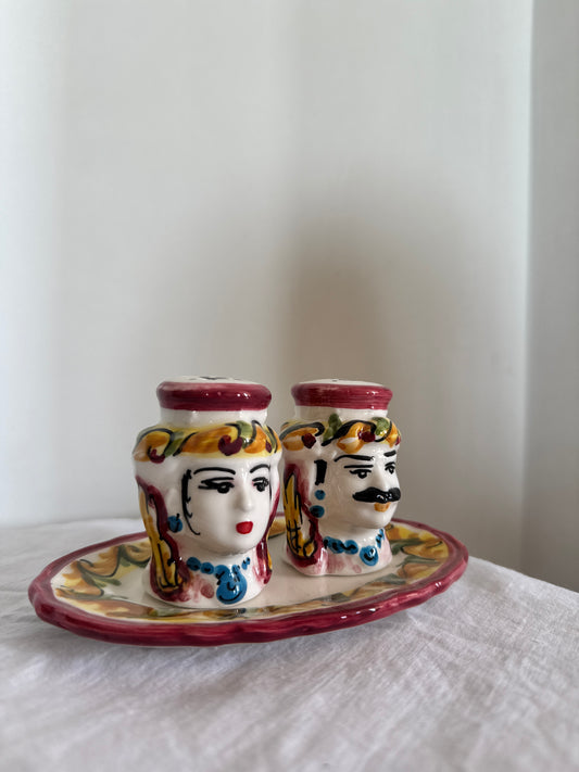 Hand-painted Sicilian Moor head salt and pepper set displayed on a decorative ceramic tray.