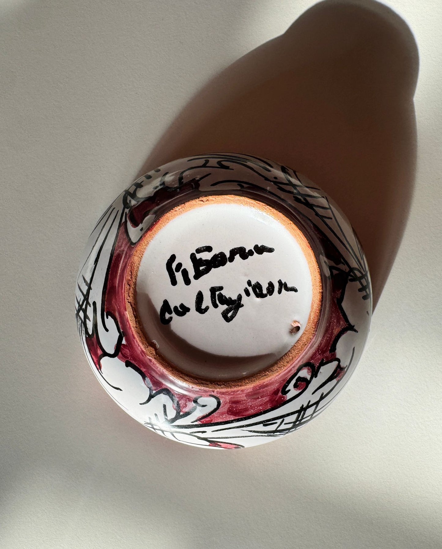 Base of handcrafted Sicilian ceramic bowl featuring the artisan signature from Caltagirone, highlighting authenticity and handmade production.