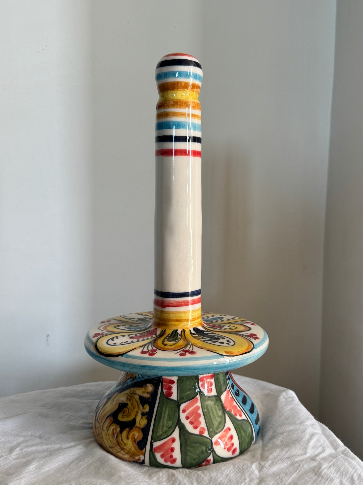 Handcrafted Sicilian ceramic paper towel holder shown by hand, highlighting its dimensions and colorful majolica decoration.