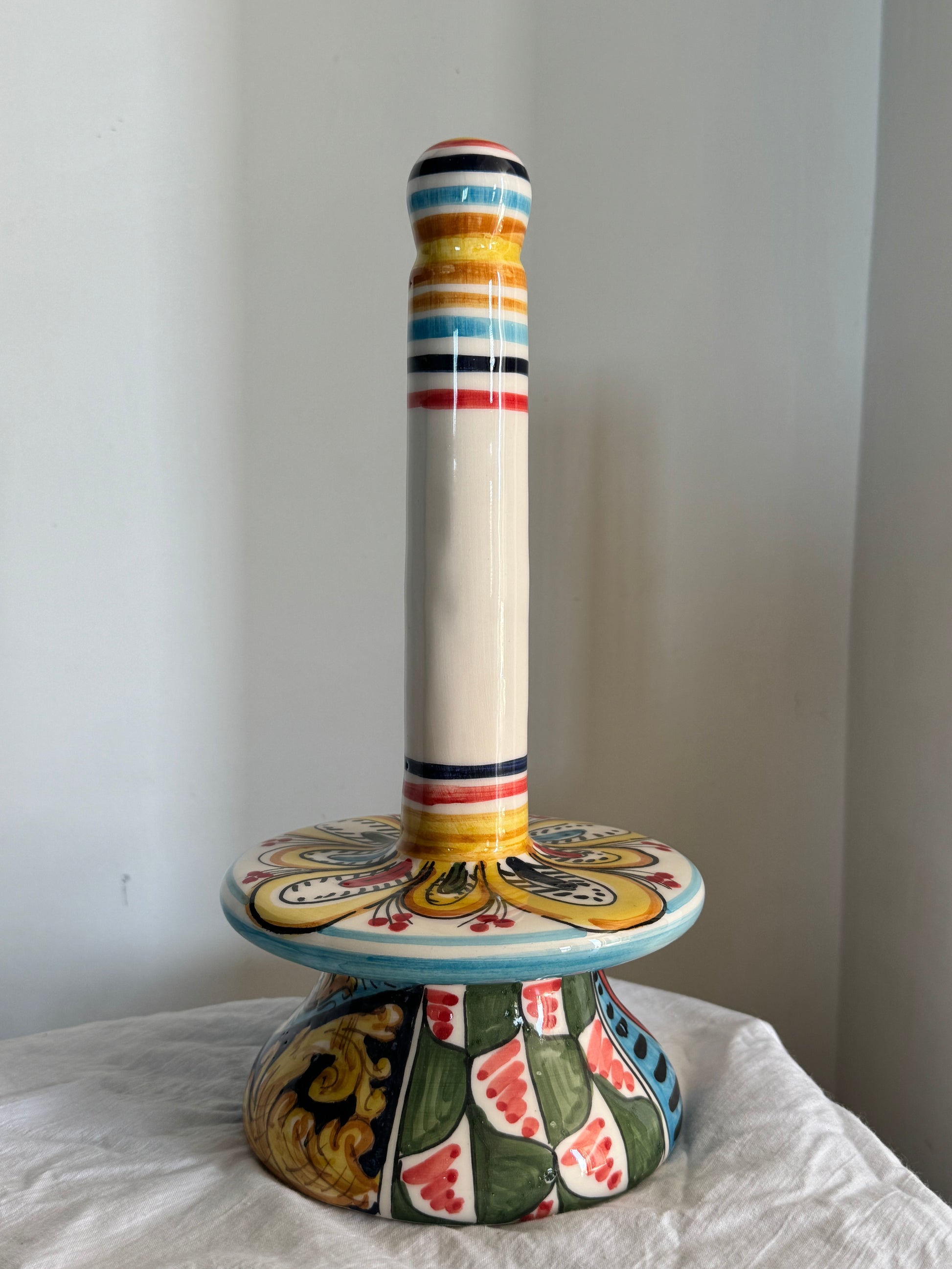 Handcrafted Sicilian ceramic paper towel holder shown by hand, highlighting its dimensions and colorful majolica decoration.